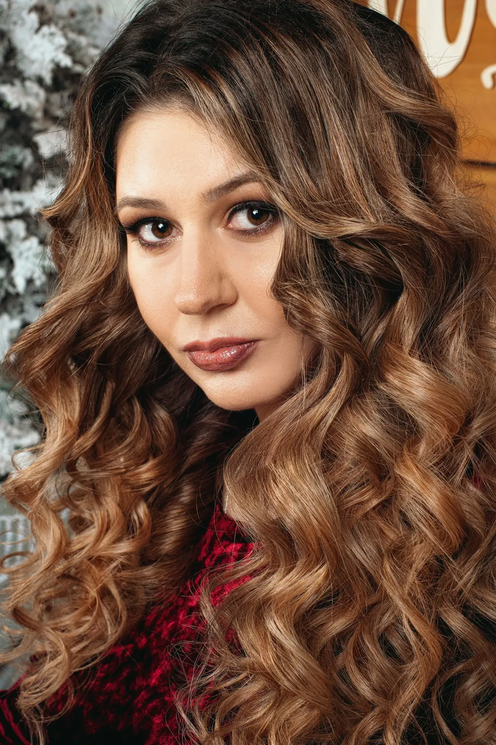 Captivating portrait of a brunette woman with long curly hair, showcasing elegance and beauty.