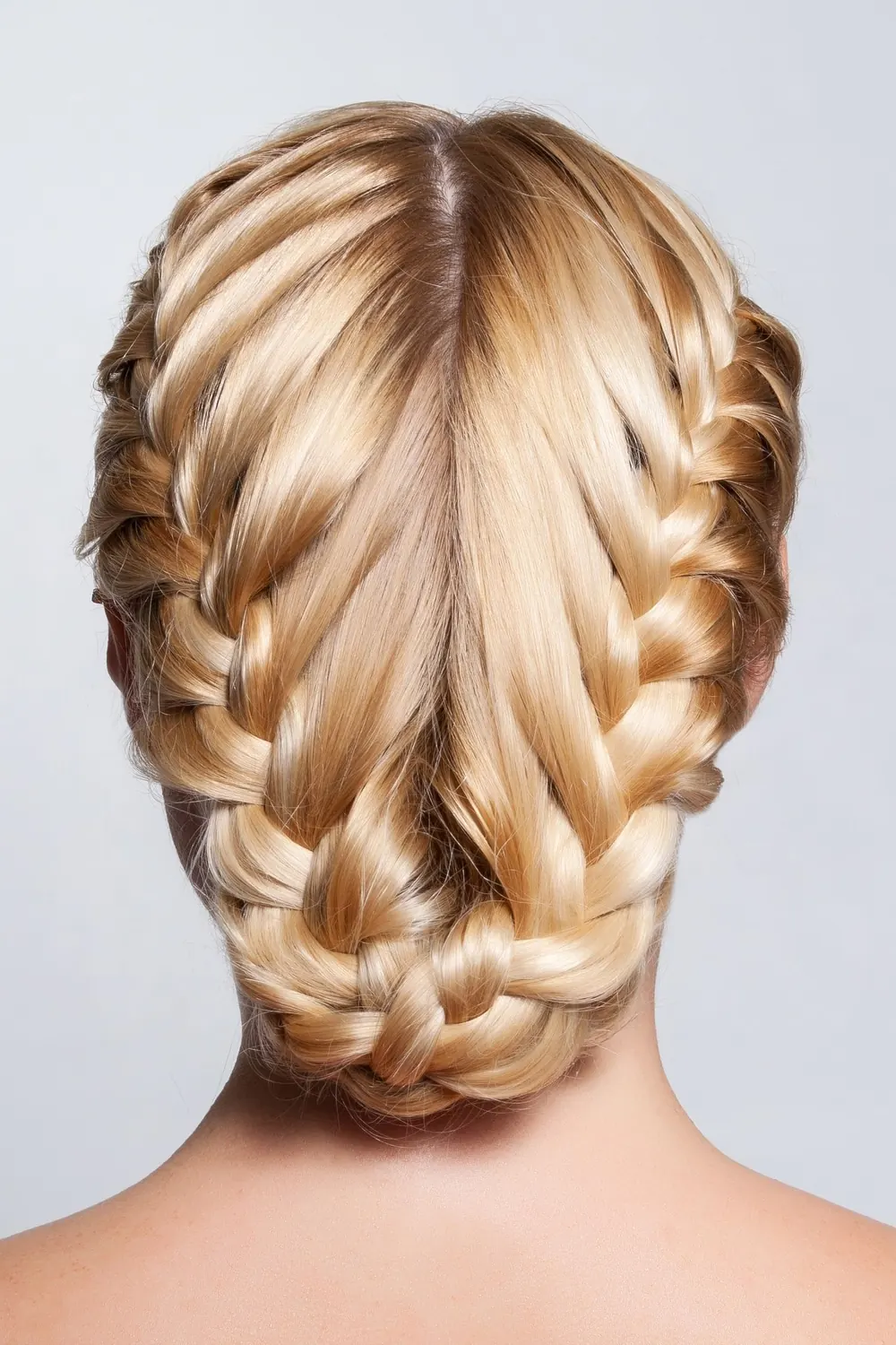 Close-up of a woman's intricate blonde braided hairstyle captured in a studio setting.