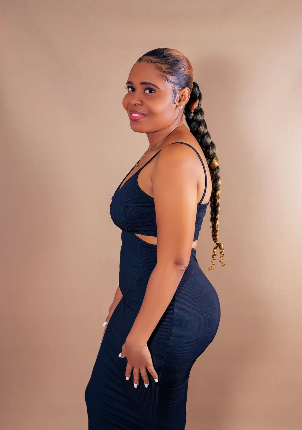 Elegant portrait of a woman in a blue dress showcasing braided hair in a studio setting.