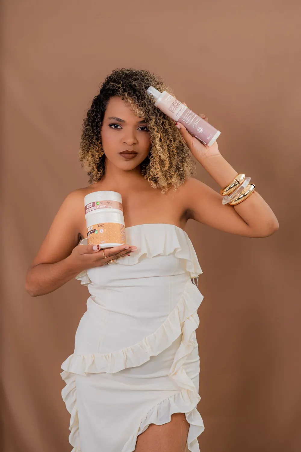 Stylish woman showcasing beauty products with a confident pose.